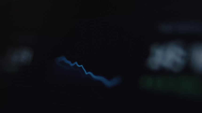 A blurry close-up of a digital financial graph shows a downward trend indicating a market crash or economic recession