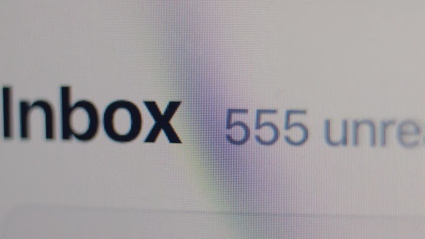 A close-up macro shot of a computer screen shows the number of unread emails in an inbox rapidly increasing