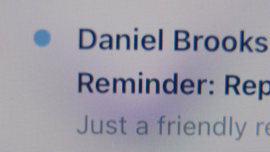 Close-up on a computer screen as a flood of work emails and notifications quickly populates an inbox