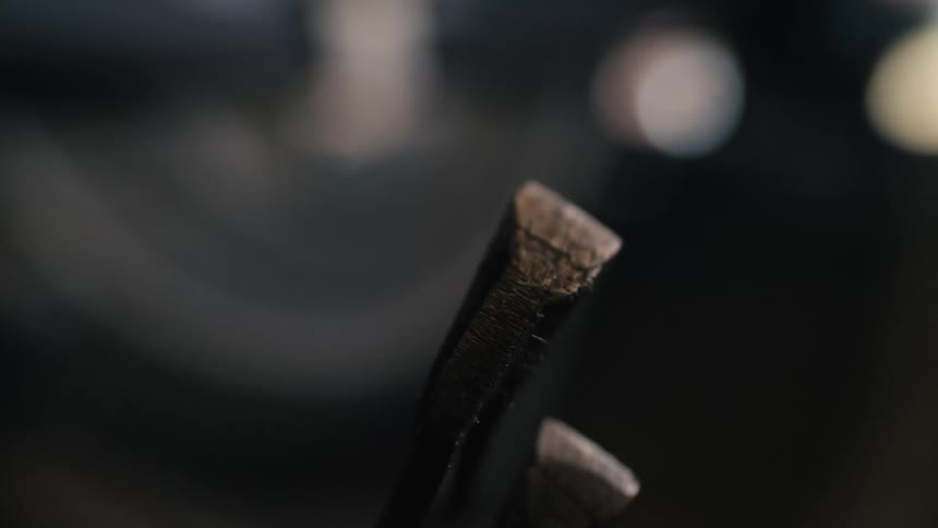 Extreme close-up of a vintage typewriter's metal hammer striking in slow motion