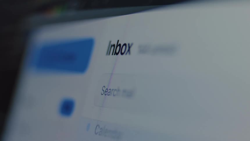 A close-up of a digital screen shows an email inbox being flooded with new messages as the unread count rapidly climbs