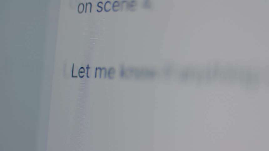 A close-up shot captures a person typing out the end of a professional email on a computer screen