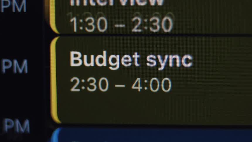 A close-up view of a digital calendar on a screen displaying a scheduled 'Budget sync' meeting