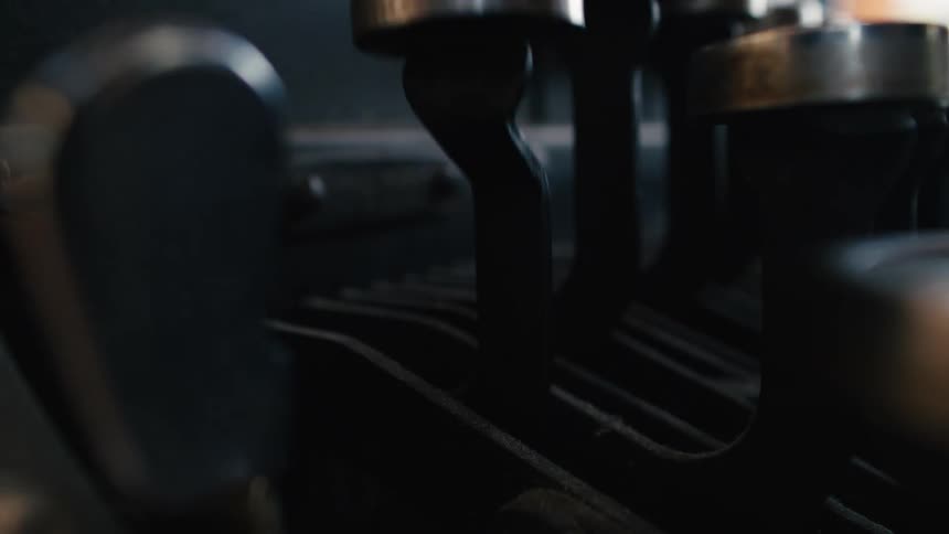 A dramatic close-up of a writer's fingers striking the dusty keys of a vintage typewriter