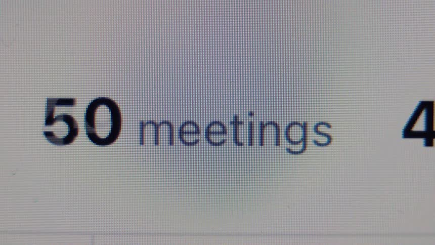 A digital counter on a computer screen rapidly increases the number of meetings, symbolizing a busy and overwhelming schedule