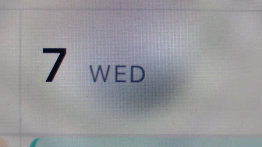 Extreme close-up of a digital calendar on a pixelated screen showing Wednesday the 7th