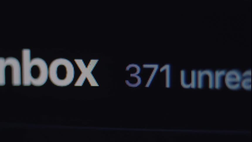 Close-up macro shot of a computer screen showing the unread email count in an inbox rapidly increasing to over 500