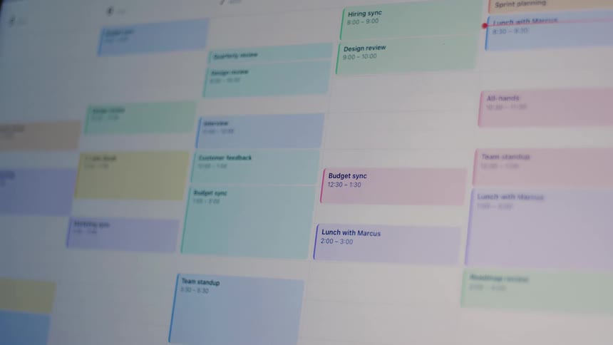 Close-up time-lapse of a busy digital work calendar being filled with appointments and meetings