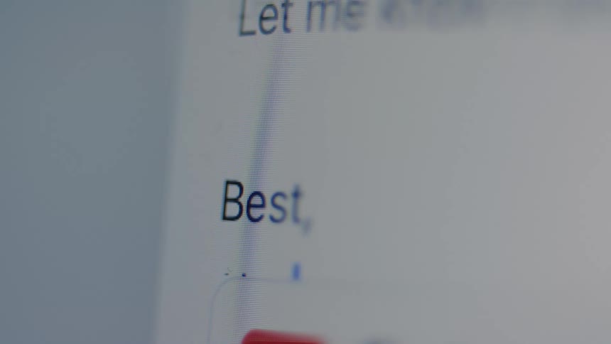 A close-up shot of a person typing the closing salutation 'Best, Alex' for an email on a computer monitor
