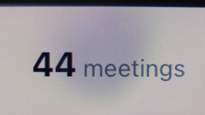 A digital counter on a screen rapidly increases the number of meetings, symbolizing a busy schedule