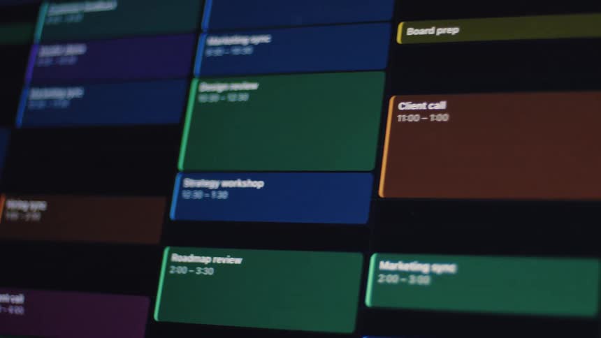 A slow pan across a digital calendar on a screen, showcasing a busy schedule of color-coded business meetings and appointments