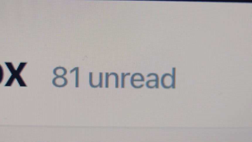 A close-up of a digital inbox shows the number of unread messages rapidly counting up