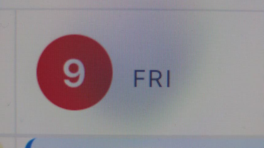 A close-up macro shot of a digital calendar on a computer screen displaying the date as Friday the 9th