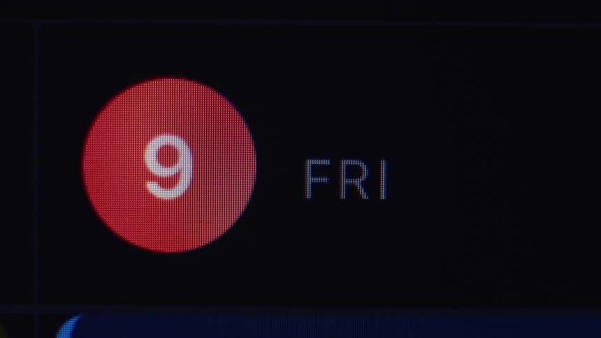 An extreme close-up of a digital display showing a notification for Friday the 9th