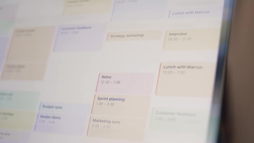 Close-up of a digital calendar being filled with a busy schedule of meetings and tasks