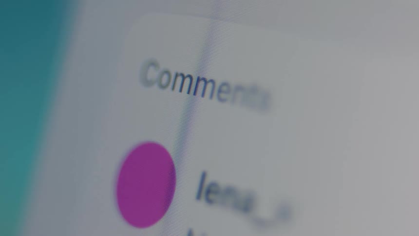 A close-up macro shot of social media comments scrolling quickly on a digital screen