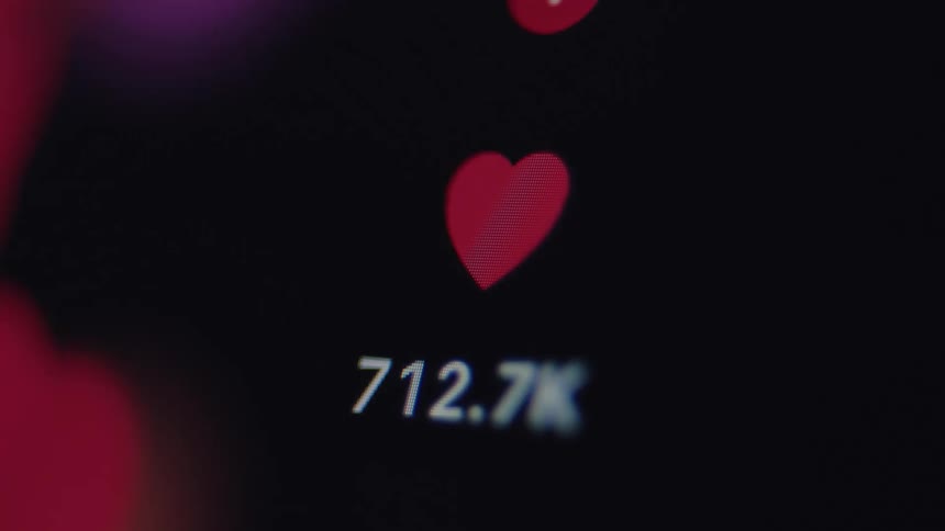 Macro close-up of a social media heart icon with the like counter rapidly increasing, symbolizing viral content and online popularity