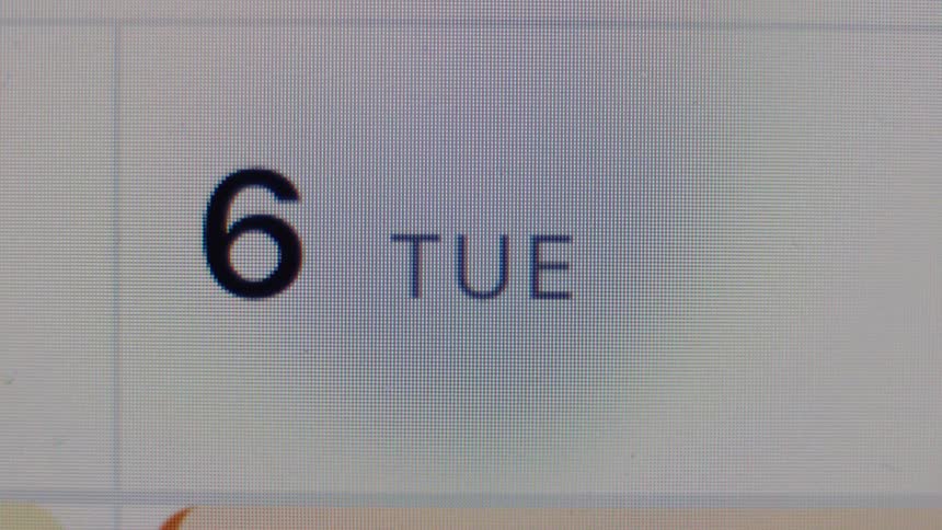 A close-up, macro view of a digital calendar on a screen showing Tuesday the 6th