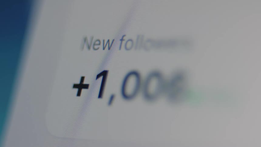 A macro view of a digital screen displays a rapidly increasing count of new followers on a social media profile