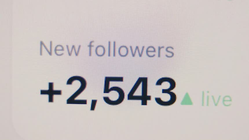 A close-up of a live counter on a screen shows a social media account rapidly gaining thousands of new followers