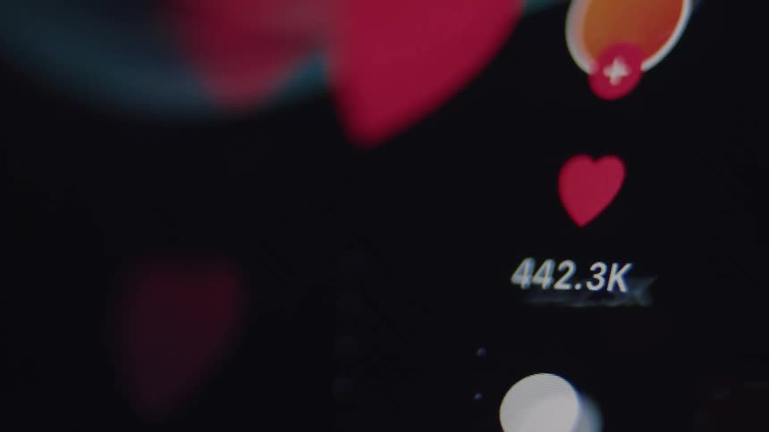 Macro shot of a social media app screen showing the like counter for a post rapidly increasing as heart icons float past