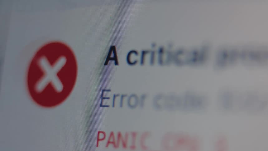 A macro close-up of a computer screen displays a critical error message and a panic warning