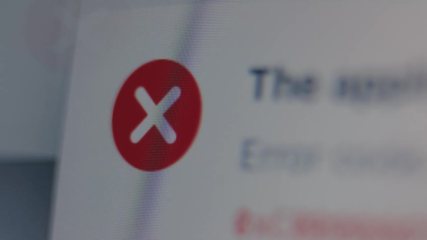 An extreme close-up macro shot of a red 'X' icon indicating an error message on a computer screen