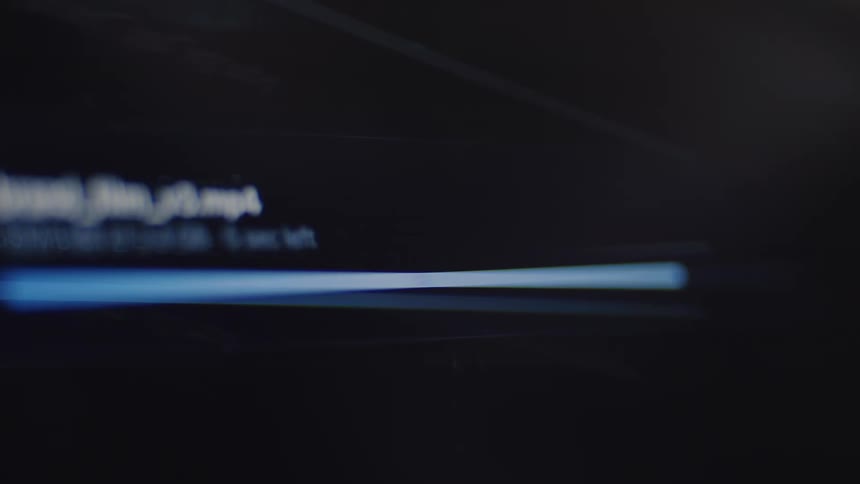 A close-up on a computer screen shows a blue progress bar indicating a file upload, which finishes with a 'File uploaded' message and a checkmark icon