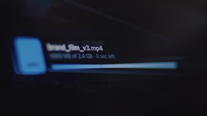 A close-up of a progress bar showing a large video file uploading, ending with a successful checkmark on a dark screen