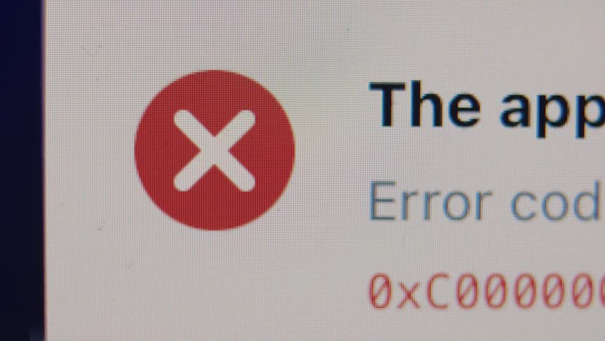 Extreme close-up of a system error message with a red X icon displayed on a computer screen
