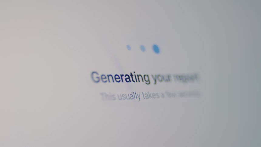 A close-up of a computer screen showing a 'Generating your report' loading animation that successfully completes with a checkmark