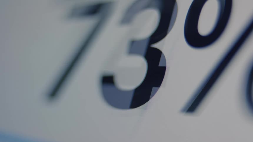 Macro shot of a loading progress bar with percentages counting up, finishing with a blue checkmark indicating success