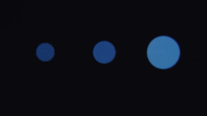 A close-up of a digital screen shows a loading animation of three pulsing dots that transitions into a successful completion checkmark
