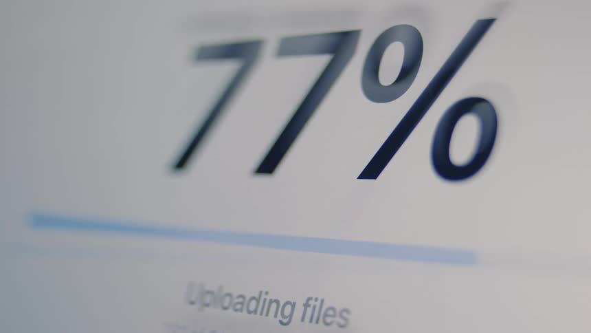 A file upload progress bar on a digital screen rapidly increases until it's complete, showing a checkmark