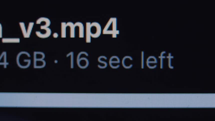 A close-up, macro shot shows a progress bar and countdown timer as a large mp4 video file downloads on a computer screen