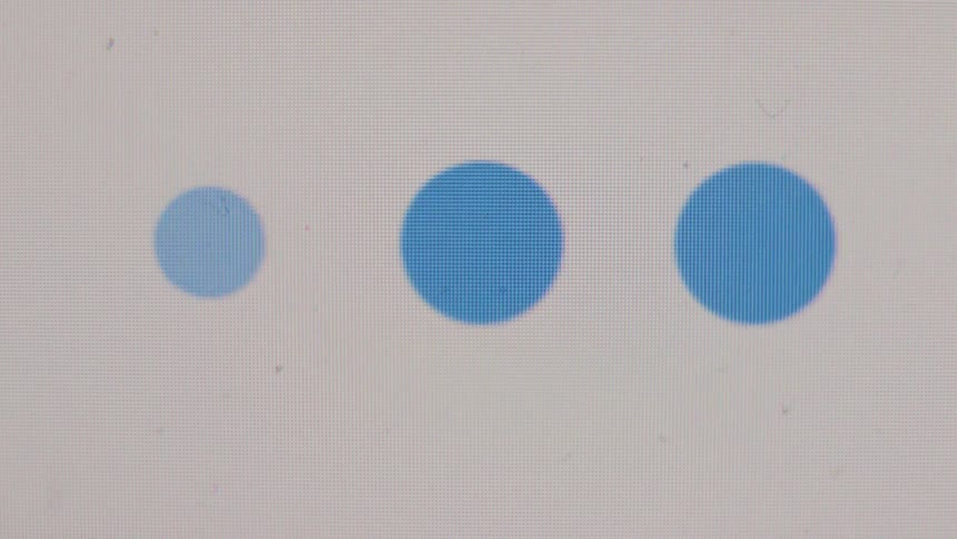 Close-up of a digital screen showing a blue loading animation with dots that transforms into a circle with a checkmark