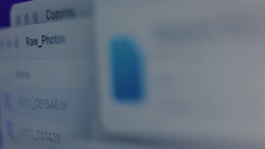 Abstract macro shot of a computer screen showing digital files being copied and organized
