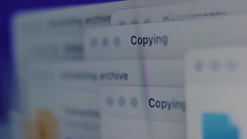 A close-up shot of a computer screen showing multiple file transfer, copying, and archiving processes running simultaneously