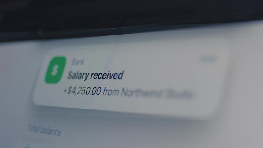 A close-up of a digital screen showing a banking app notification for a salary payment of $4,250 being received