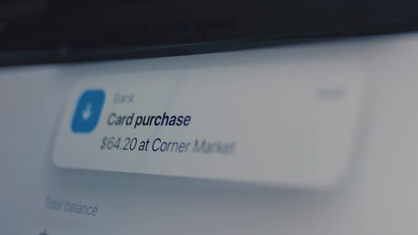 An extreme close up shows a digital banking app push notification for a recent card purchase