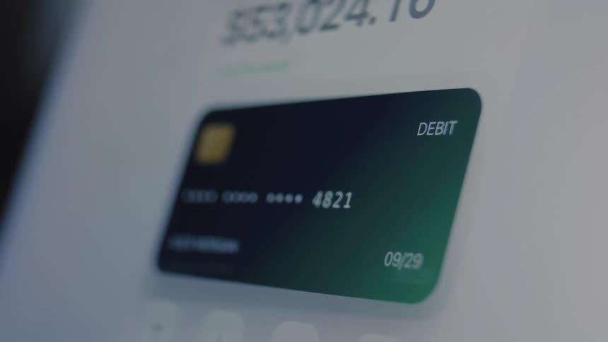 Close-up of a digital banking interface on a screen showing a debit card and a rapidly decreasing account balance