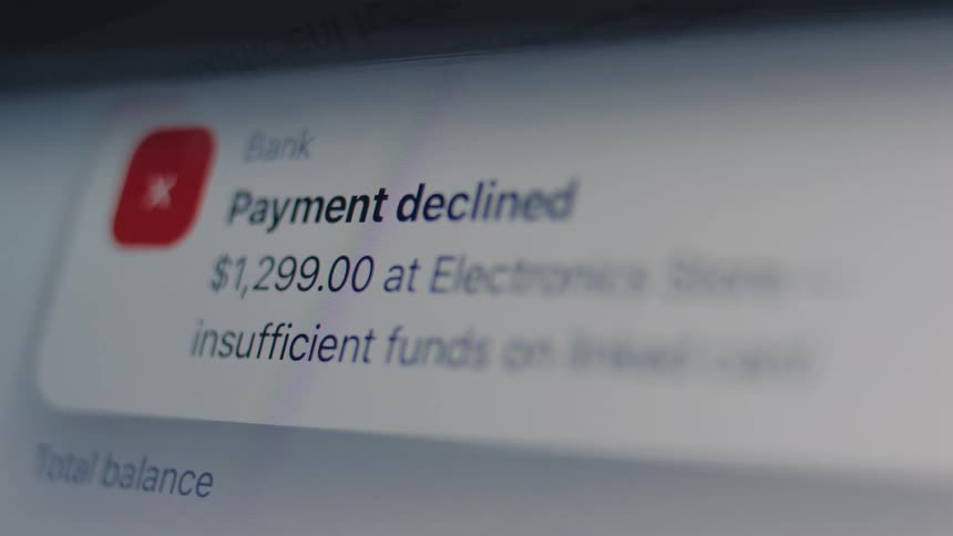 A close-up of a digital screen showing a 'payment declined' notification for an electronics store purchase due to insufficient funds