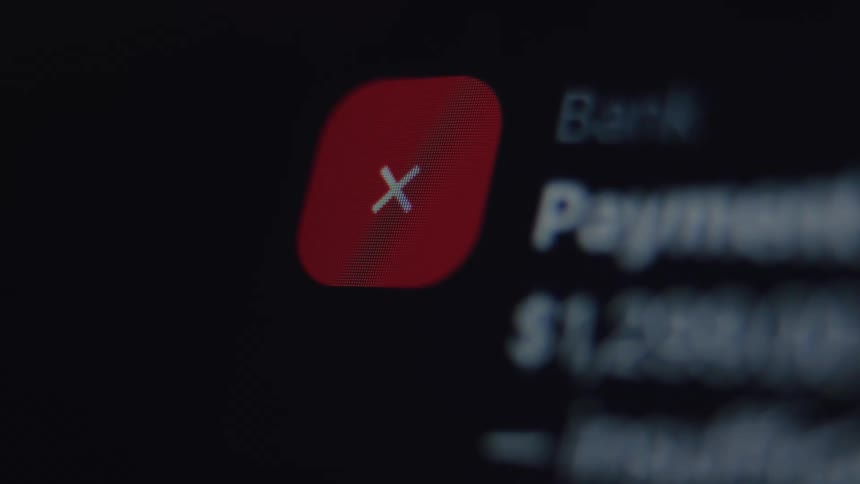 A close-up macro shot shows a failed payment notification on a digital screen, indicating insufficient funds