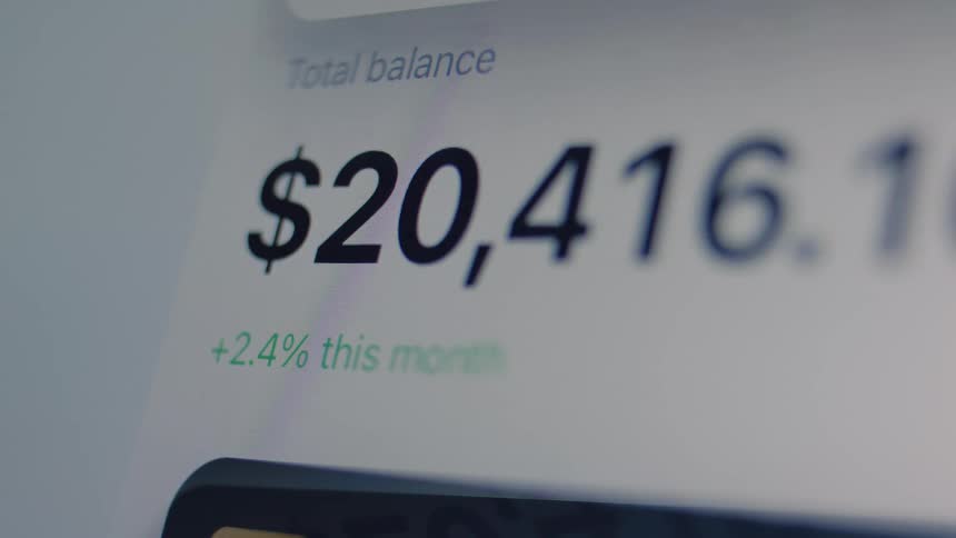 A close-up of a financial account balance on a digital screen flashing red as an alert