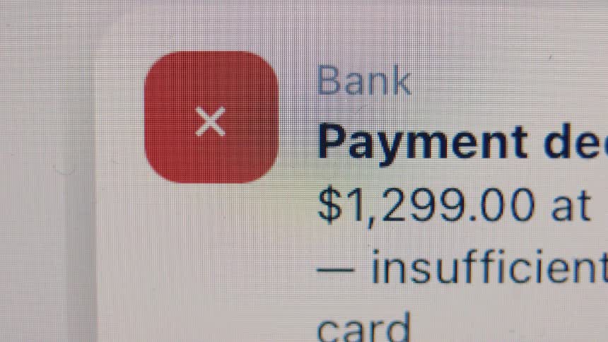 A close-up of a 'Payment Declined' notification from a bank app due to insufficient funds on a digital screen
