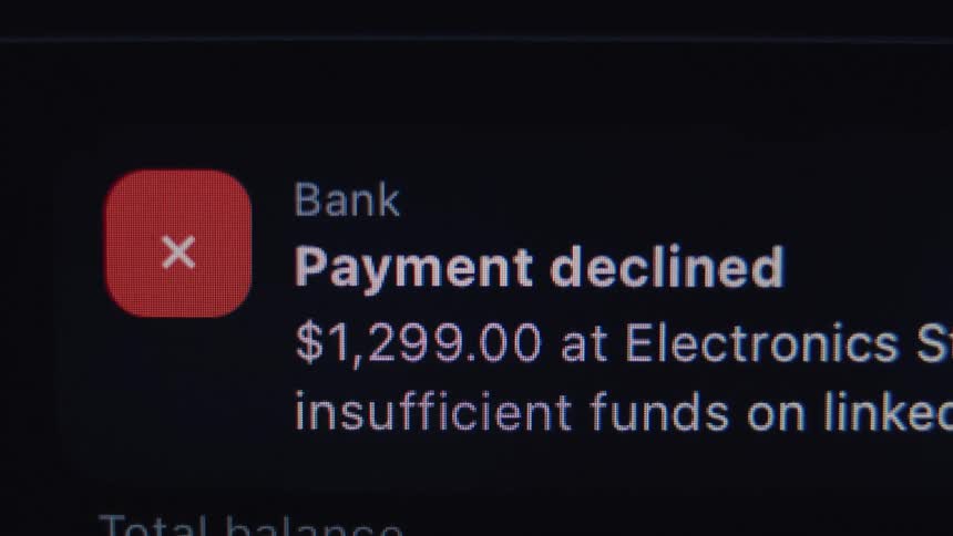 A close-up shot of a digital screen showing a 'payment declined' notification due to insufficient funds, with a glitch effect