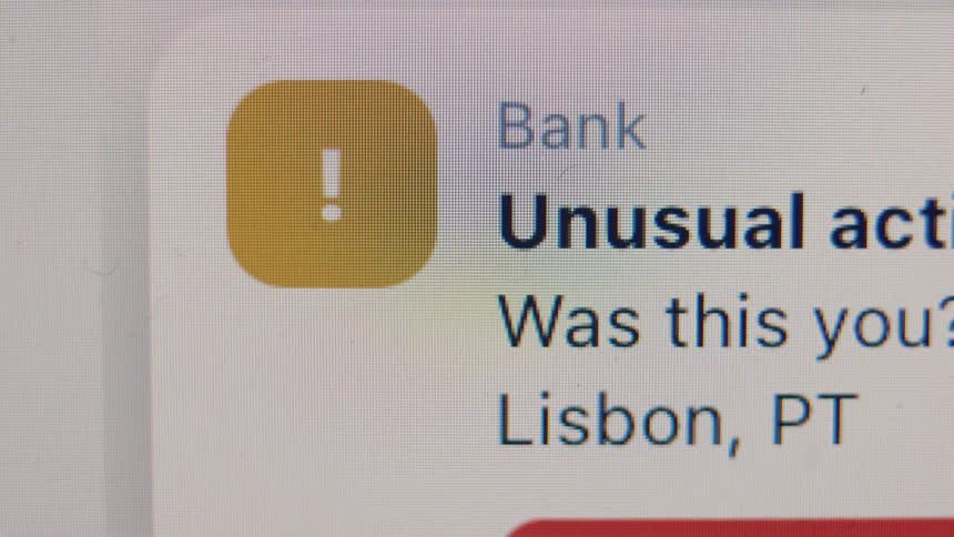 Close-up macro shot of a bank fraud alert for unusual activity appearing on a digital screen