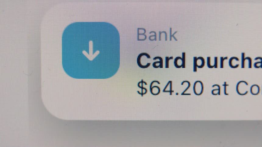 An extreme close-up of a digital banking app screen showing a credit card purchase transaction