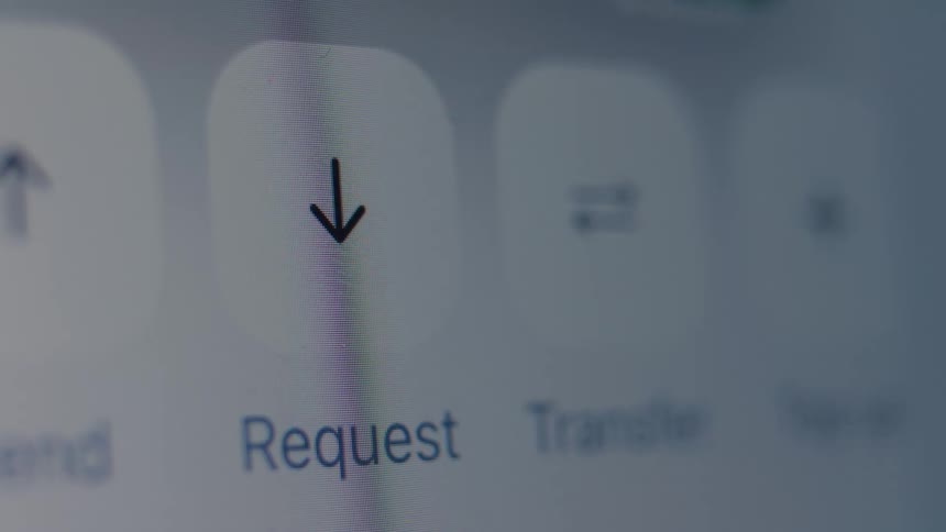 A macro shot of a finger tapping the 'Request' button on a mobile banking application to initiate a money transaction
