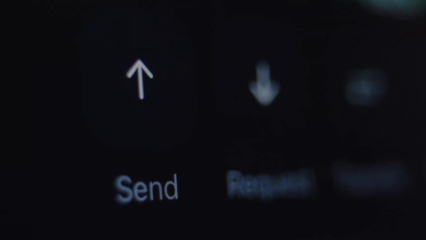 A close-up, out-of-focus shot of a finger tapping the send and request buttons on a digital banking app screen